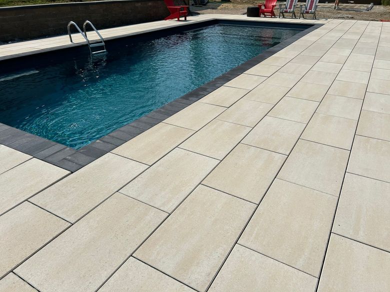 Brick house with landscaped yard; stone retaining walls, steps, colorful flowers, and mulch.