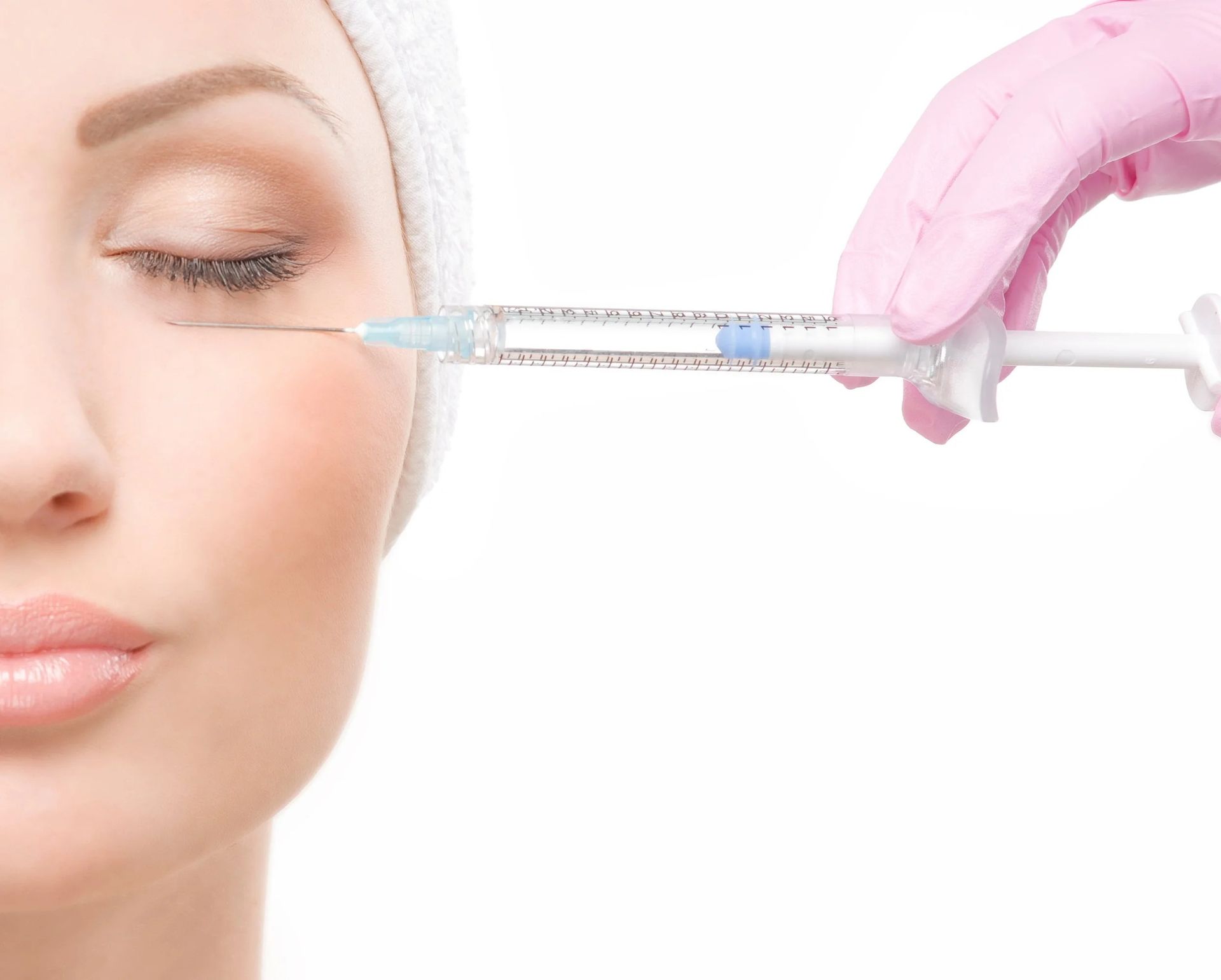 Woman receiving cosmetic injection near eye, being injected by a gloved hand.