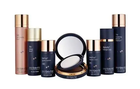 Collection of skincare and makeup products with gold and navy packaging.