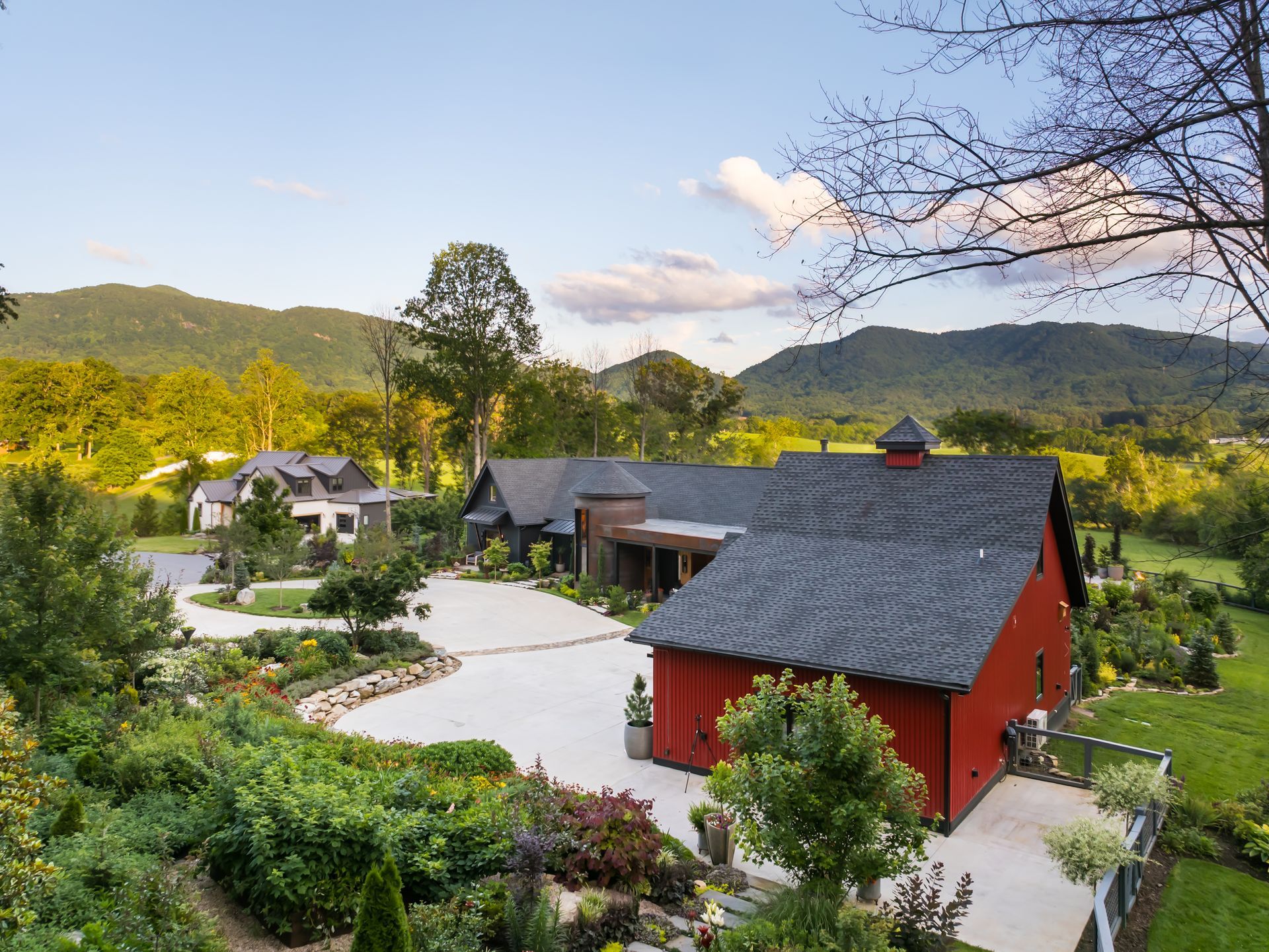Red barn-style building by a winding path in a green mountain resort landscape