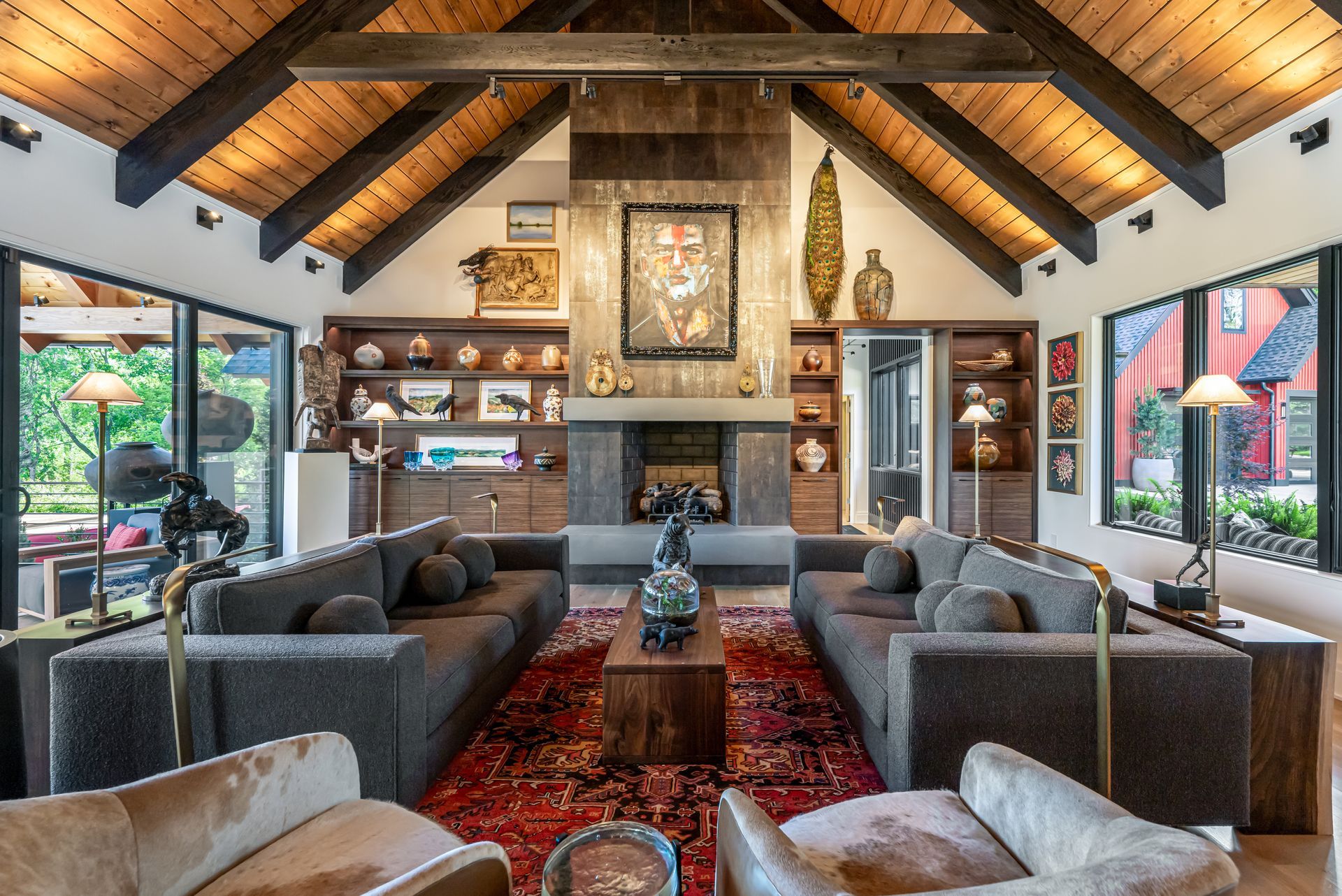 Cozy living room with vaulted wood ceiling, gray sofas, fireplace, and red patterned rug