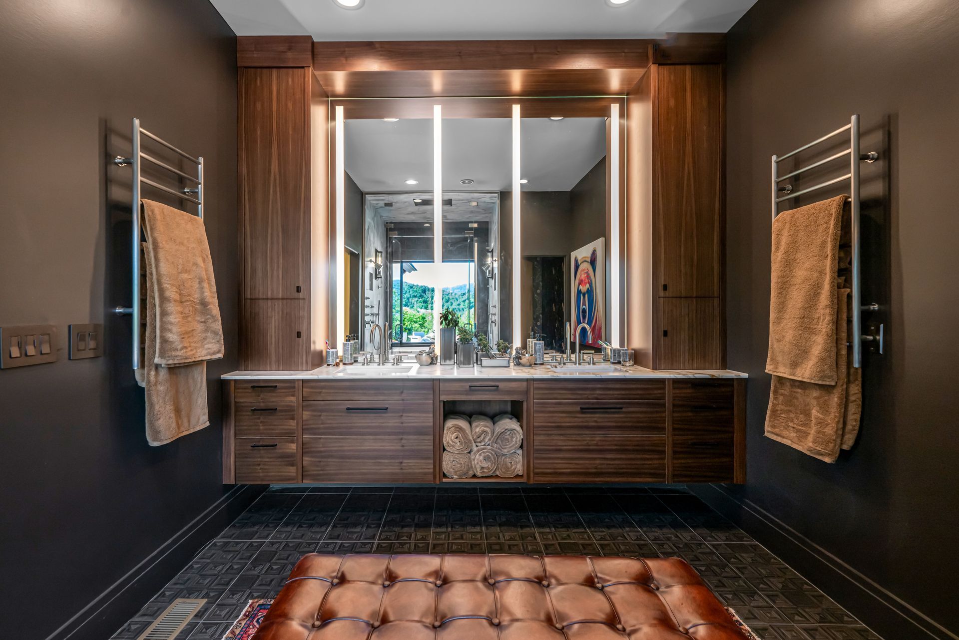 Modern bathroom vanity with double mirrors, wood cabinets, and towels on wall racks