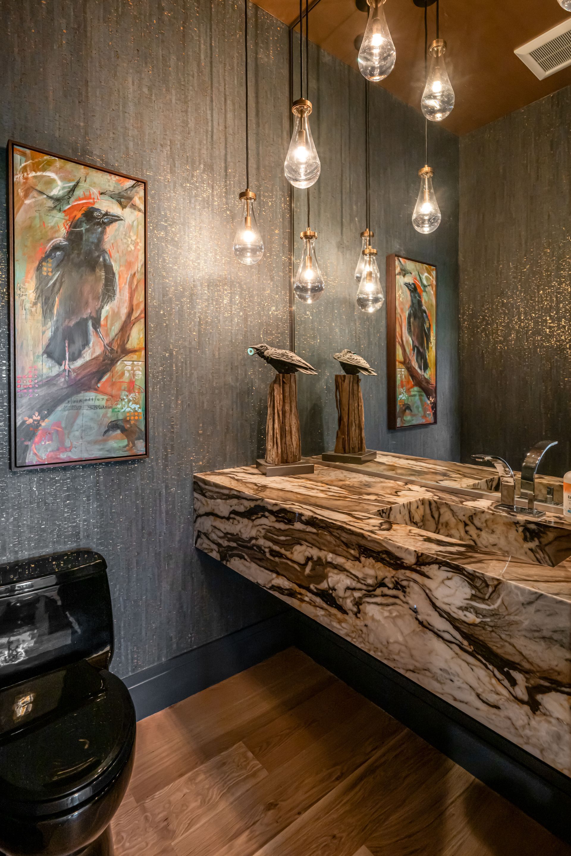Elegant spa reception with stone counter, hanging pendant lights, artwork, and a dark leather chair