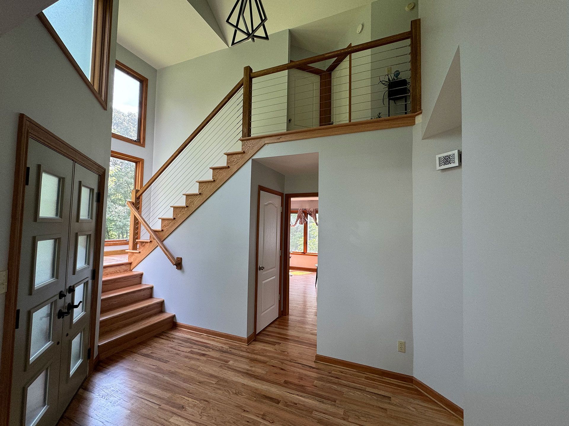 A hallway with stairs leading up to the second floor of a house.