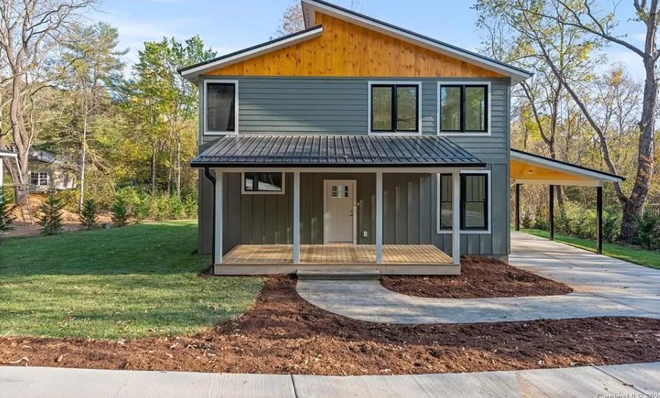 A gray and yellow house with a porch and a concrete driveway.