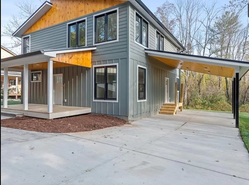 A gray house with a porch and a carport
