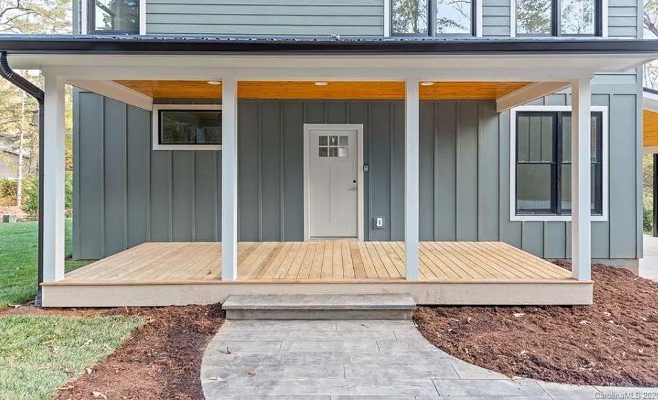 The front of a house with a porch and a walkway leading to it.