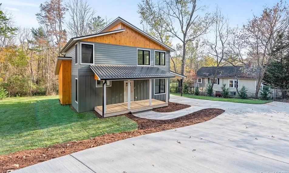 A large house with a lot of windows and a driveway in front of it.