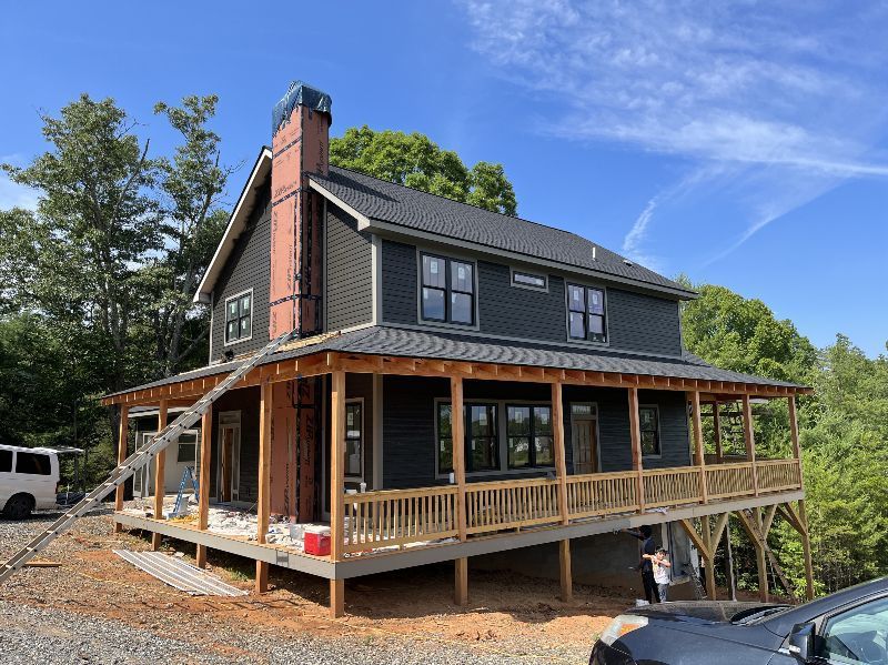 A large house with a large porch and a car parked in front of it.