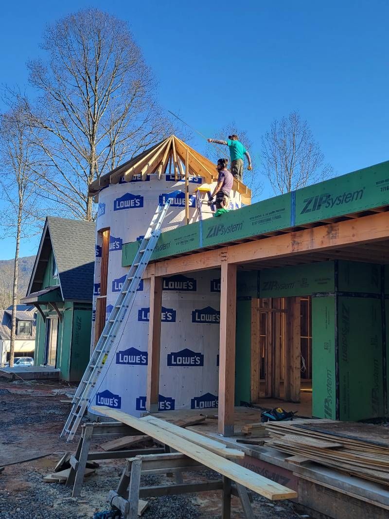 A group of people are working on the roof of a building under construction.