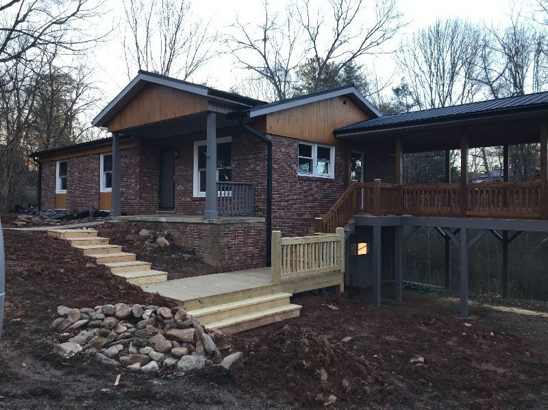 A brick house with a wooden deck and stairs