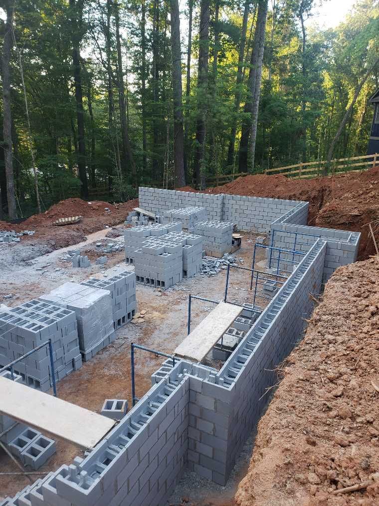 A brick wall is being built in the middle of a forest.