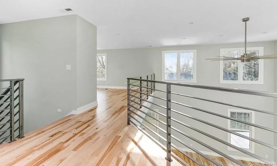 An empty room with hardwood floors and a ceiling fan