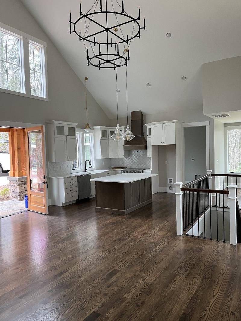 A kitchen with a large island and a chandelier hanging from the ceiling.
