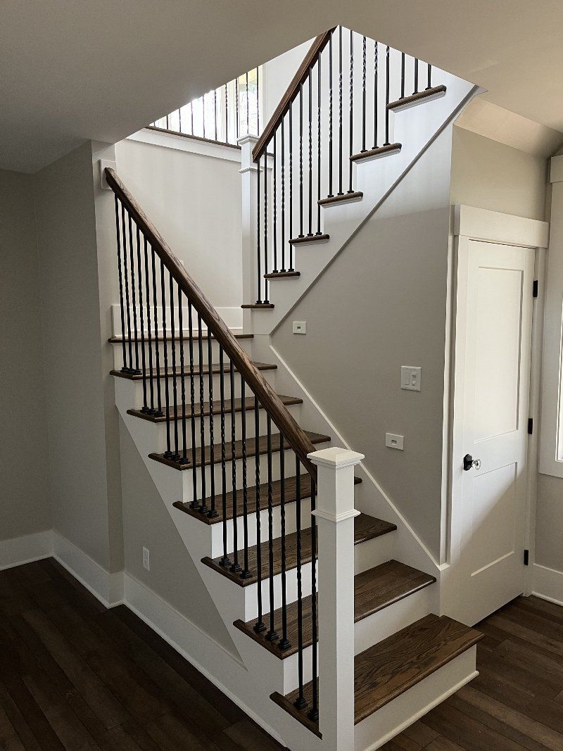 A staircase with wooden steps and a metal railing in a house.