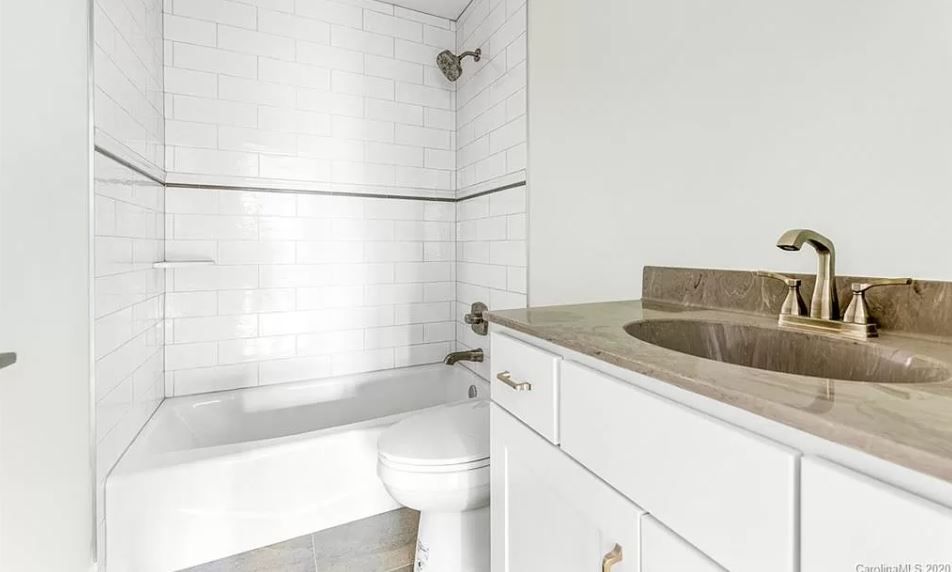 A bathroom with a toilet, sink, and bathtub.