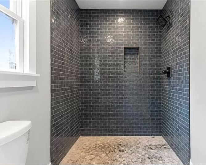 A bathroom with a walk in shower and a toilet.