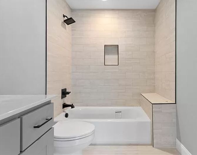 A bathroom with a toilet, bathtub, and shower.