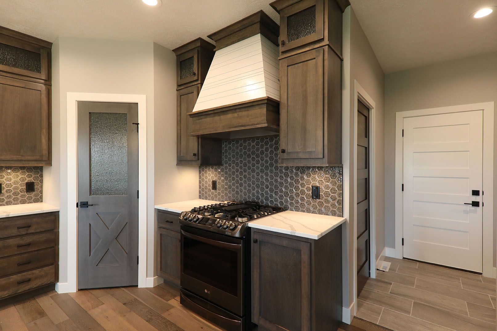 A kitchen with a stove , cabinets , and a door.