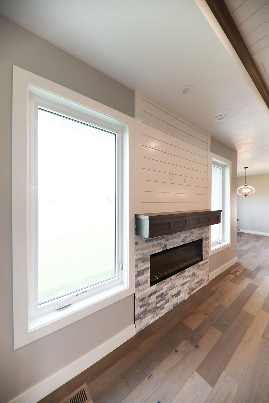 A living room with a fireplace and a lot of windows.