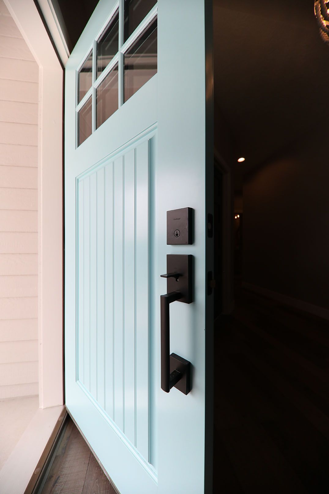A close up of a blue door with a black handle.
