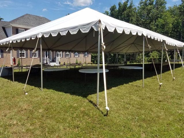a large white tent with tables underneath it