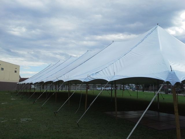 a large white tent is sitting in the middle of a grassy field