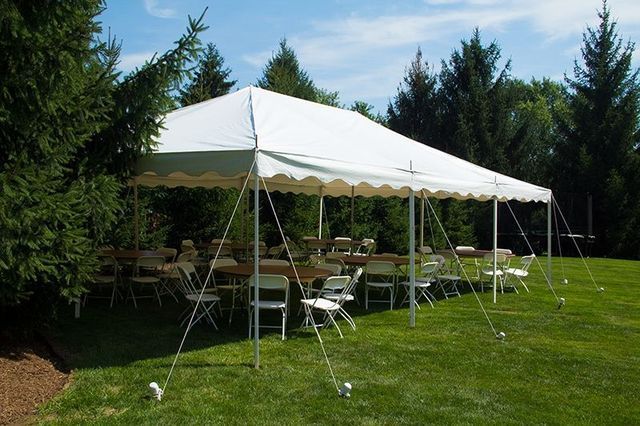 a large white tent with tables and chairs underneath it