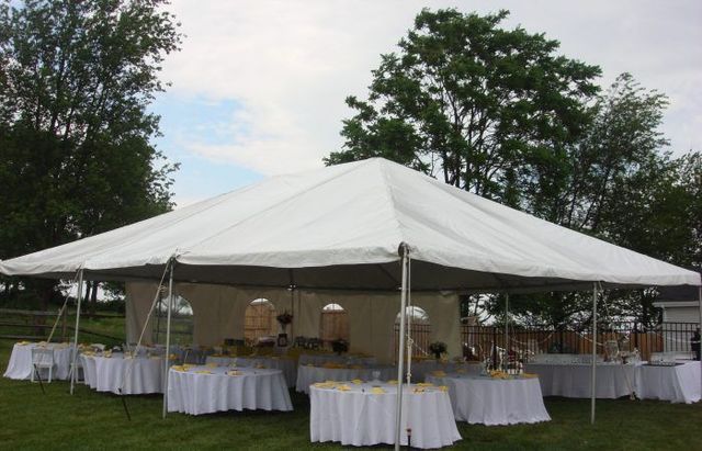a large white tent with white tables underneath it