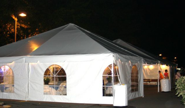 a large white tent is lit up at night