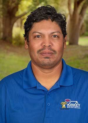 Man in blue polo shirt with company logo, standing outdoors with a neutral expression.
