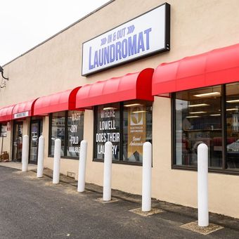 A laundromat with red awnings and white poles