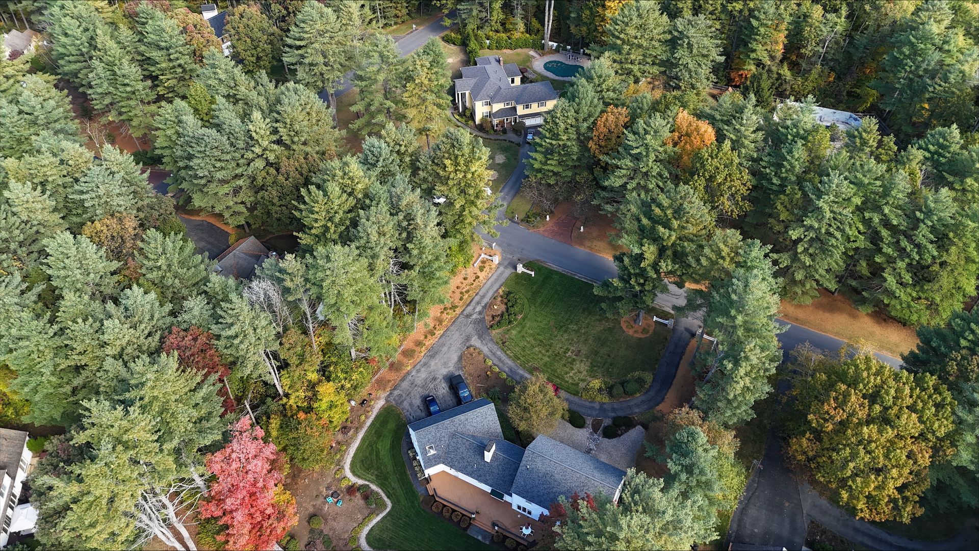 An aerial view of a house in the middle of a forest.