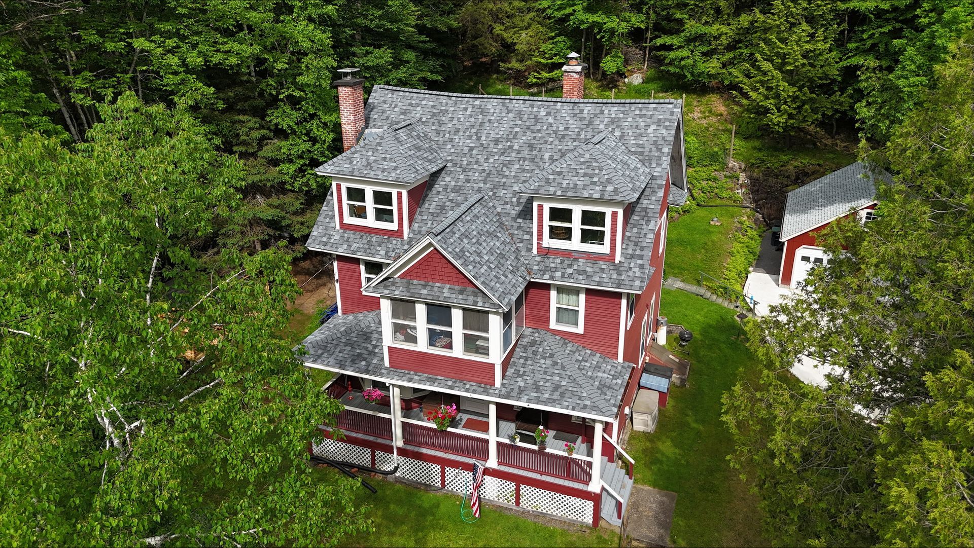 An aerial view of a large red house surrounded by trees.