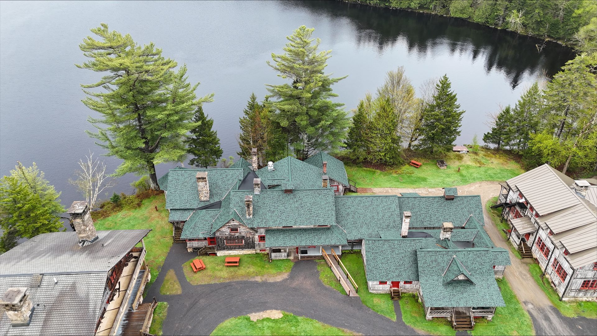 An aerial view of a large house next to a lake