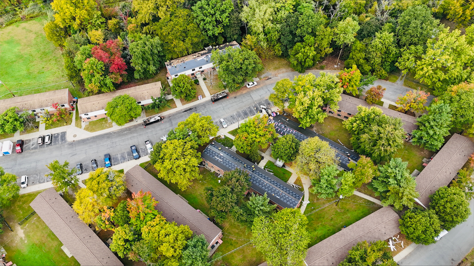 An aerial view of a residential area surrounded by trees and buildings.