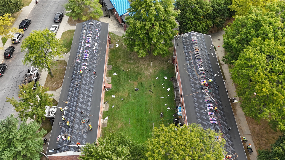 An aerial view of a building with a lot of shingles on the roof.