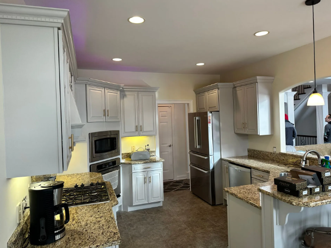 White kitchen with granite countertops and stainless steel appliances.