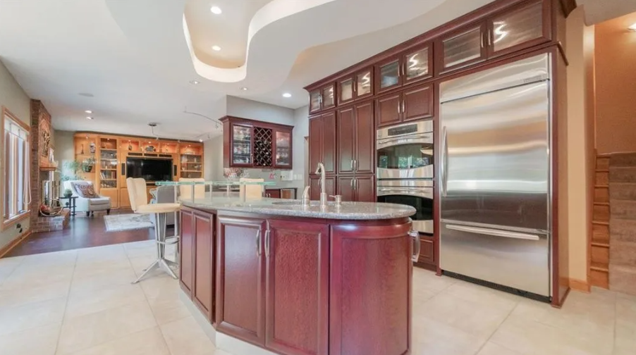 Large, modern kitchen with a large stainless steel refrigerator and dark wood cabinetry.