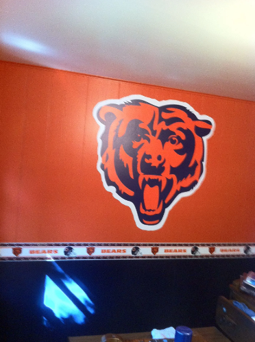 Chicago Bears logo on orange wall, with logo-themed border below.
