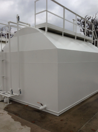 White rectangular storage tank with access ladder and platform.