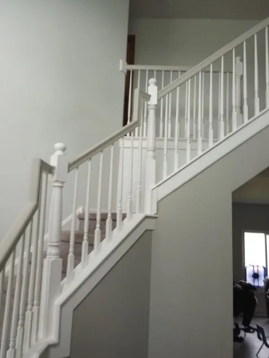 White staircase with matching railing against gray and white walls.