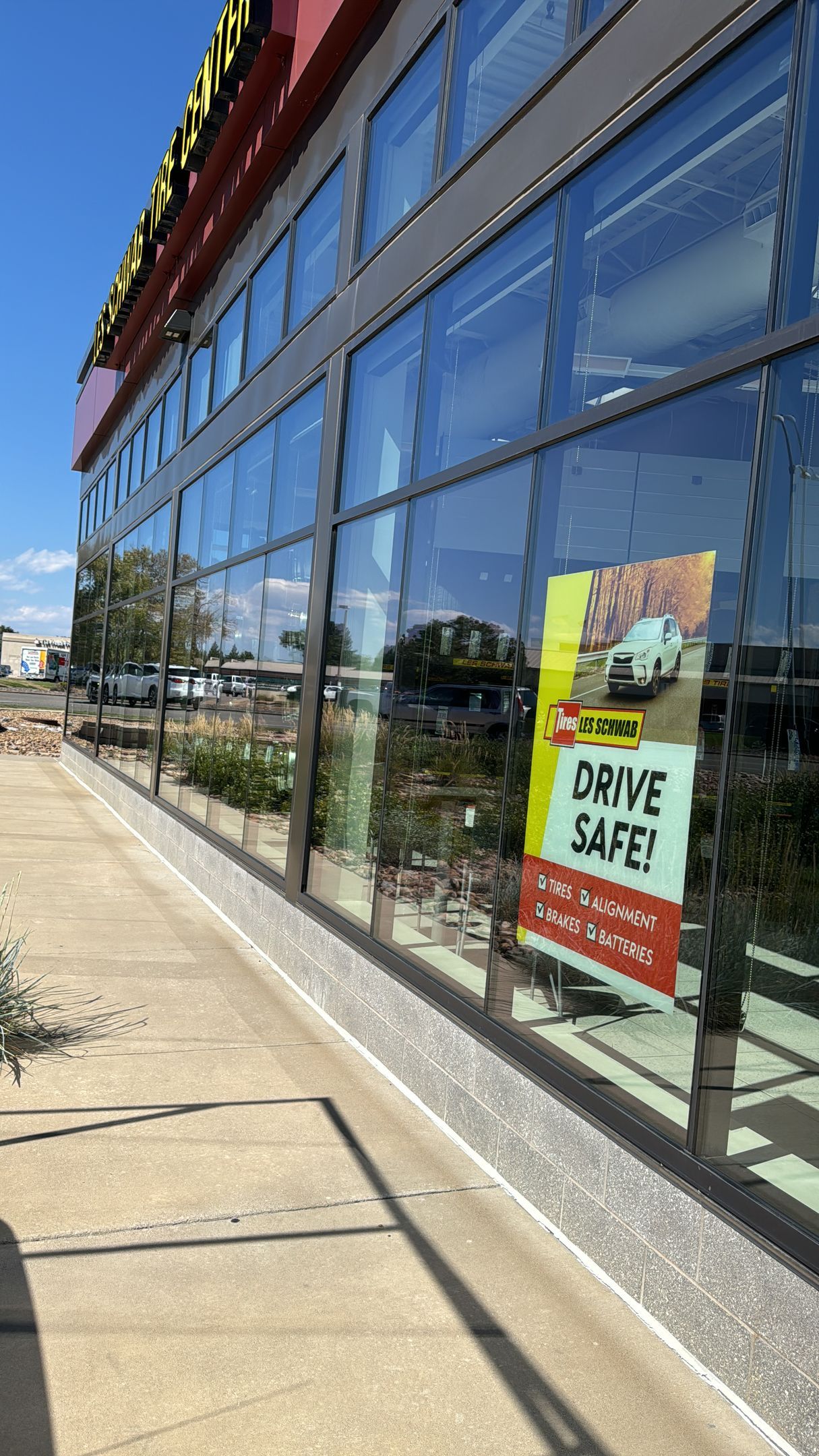 Building with large windows, reflection of the street, and a 