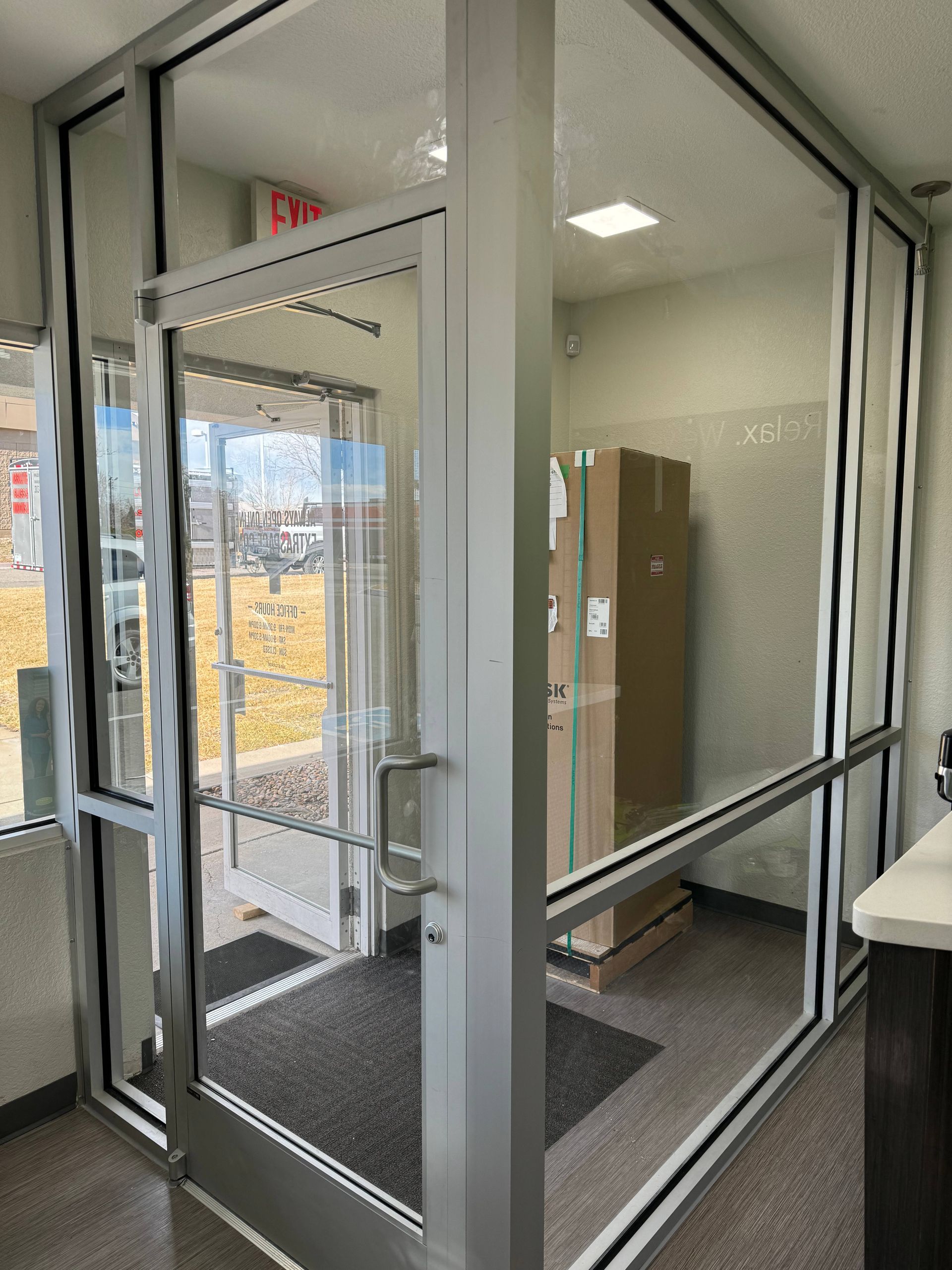 Glass entrance doors and a vestibule, with a cardboard box visible inside.