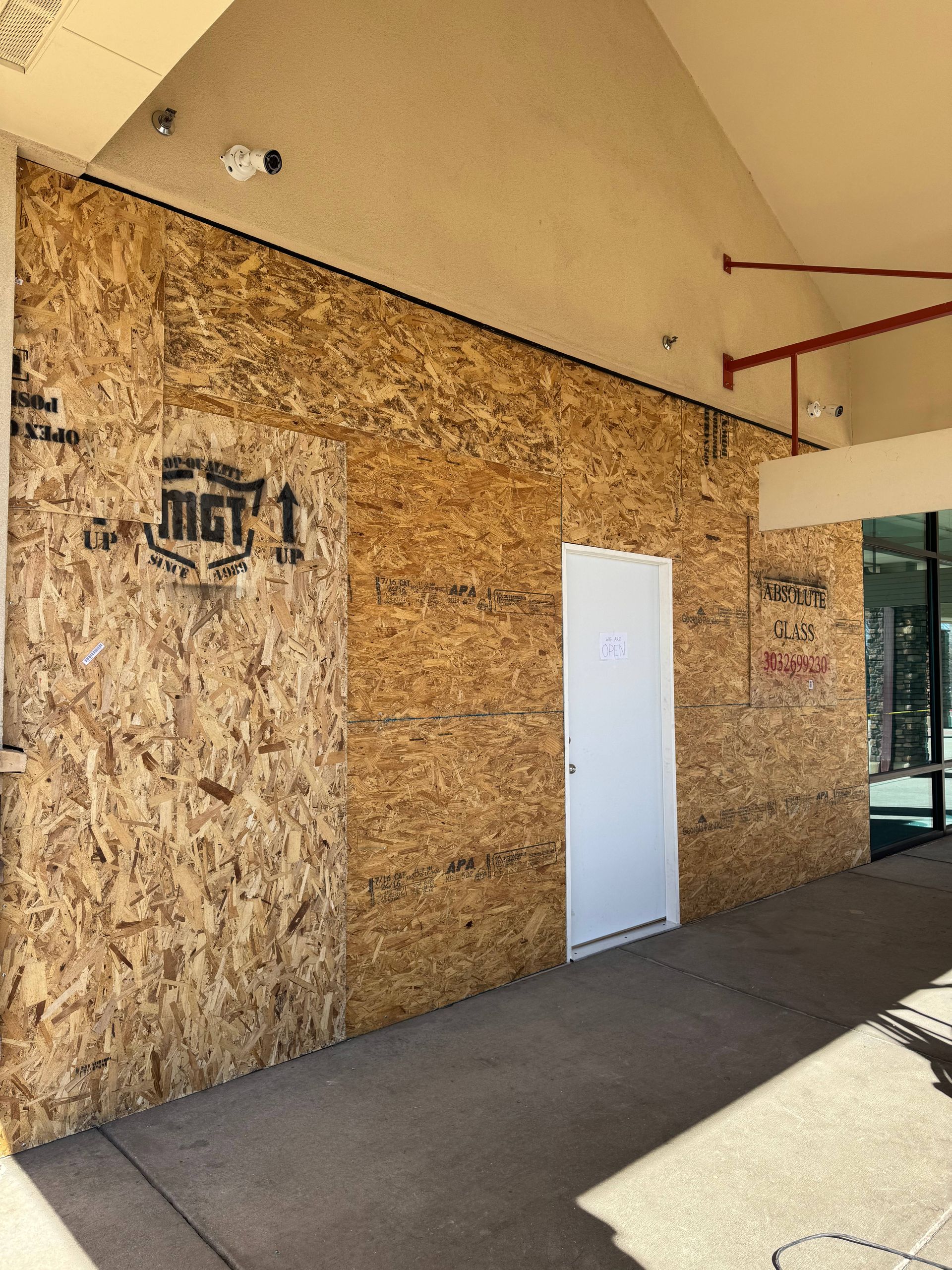 A white door is surrounded by wooden boards on a building exterior.