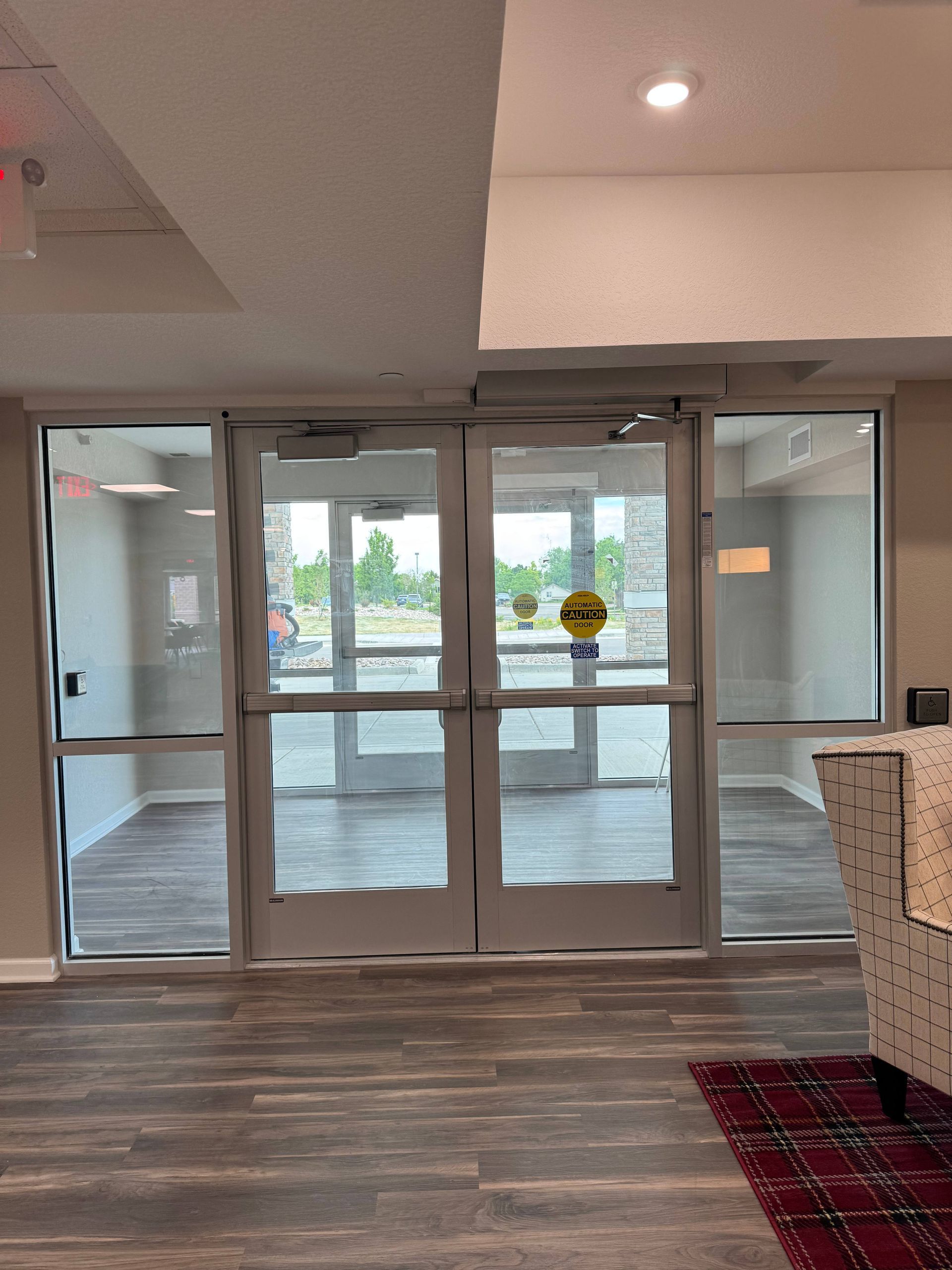 Glass double doors lead to the outside. The doors have automatic openers and a push bar.