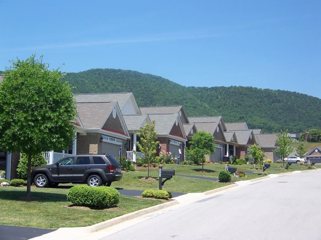 Suburban homes on a sunny day with a mountain backdrop.