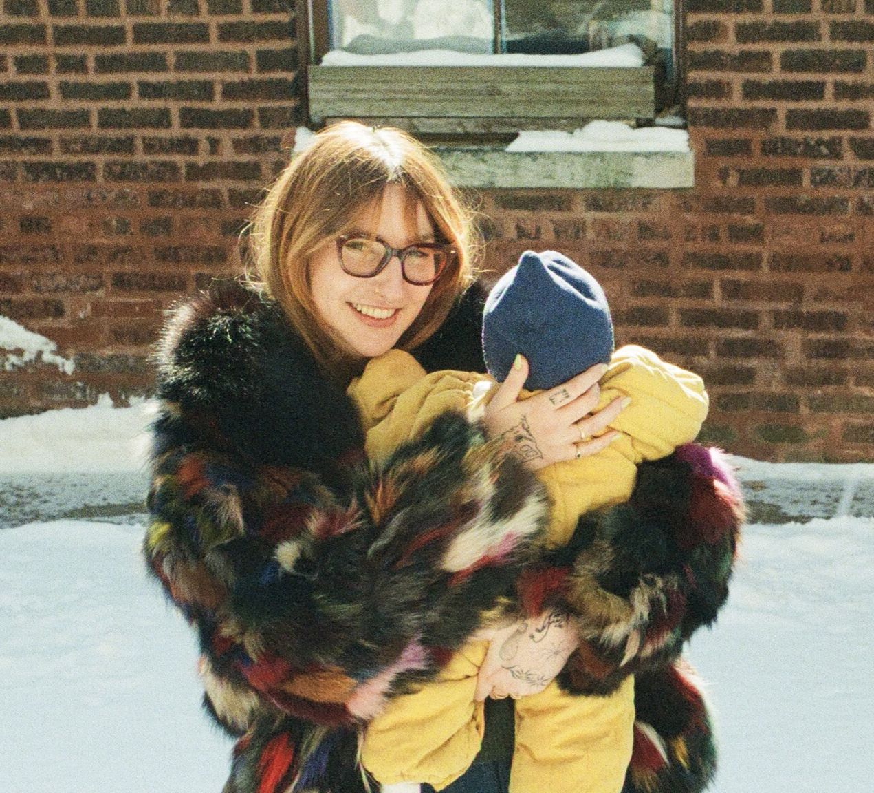 A person with blue eyes, smiling, wearing a blue sweater.