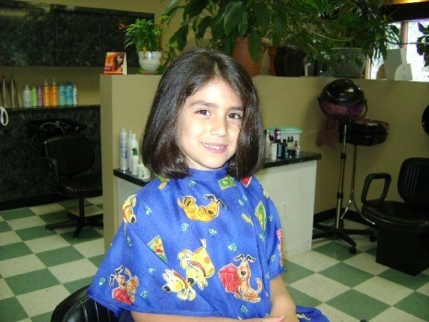 a little girl wearing a blue cape with animals on it