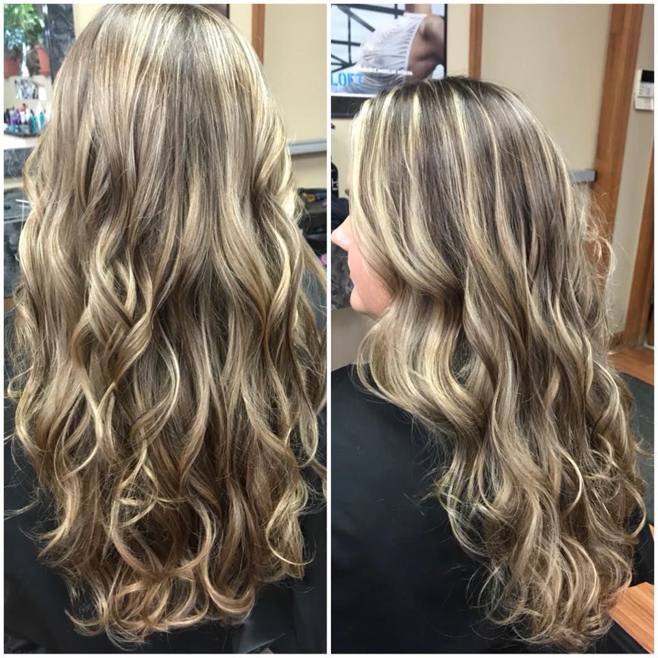 a woman with long blonde hair is sitting in a chair.